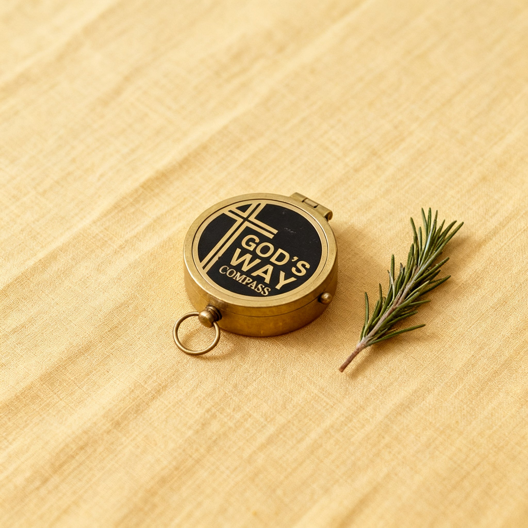 Brass compass resting on an open Bible in morning light.